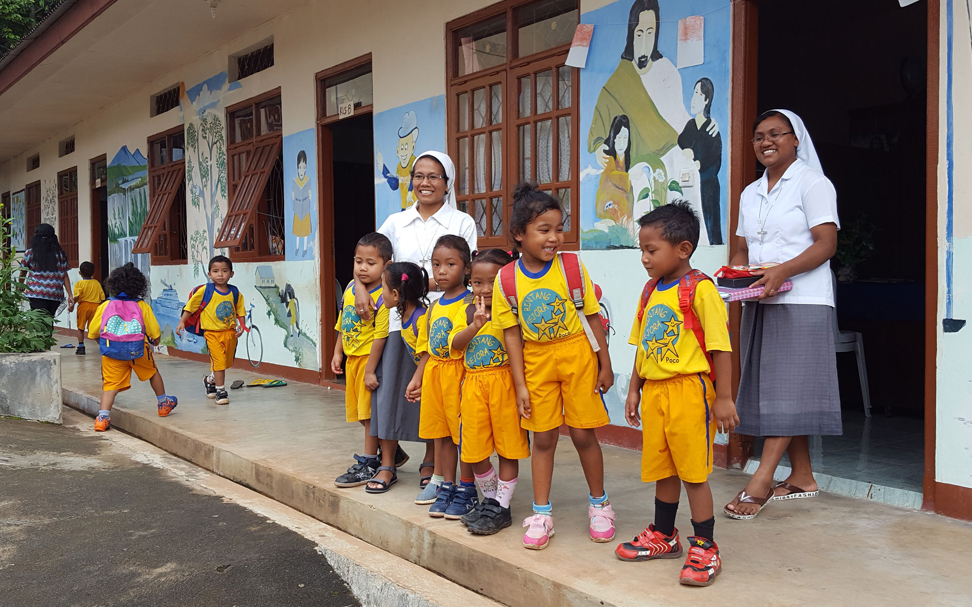 Small children standing in front of school